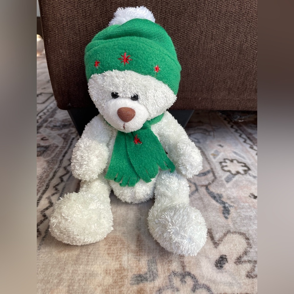 Cozy vintage-white teddy bear with green accessories with Christmas music